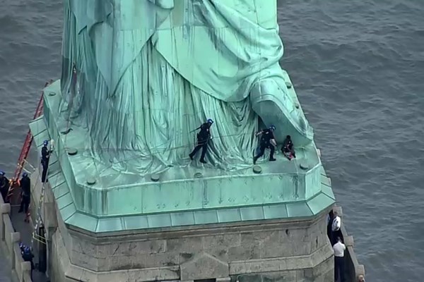 زن آمریکایی در اعتراض به سیاست‌های مهاجرتی ترامپ از «مجسمه آزادی» بالا رفت (+عکس)