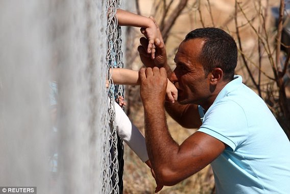 بوسه بر فرزند پناهجوی سوری از پشت حصار(+عکس)